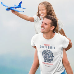Dad in a white shirt with a head-shaped QR code and the words “Awesome Dad's Brain – Now Scannable,” carrying daughter playing with a toy airplane.